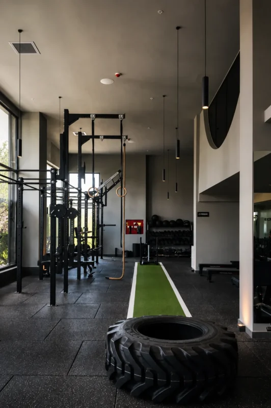 Personal trainer coaching a client through a squat in a condo building gym