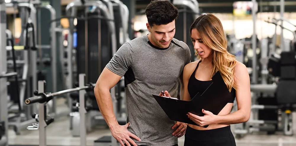 Personal trainer reviewing a training plan with a client at a first session