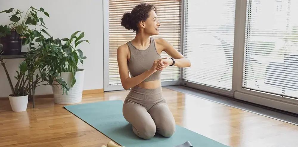 Woman resting on a mat between exercises in a home prenatal workout